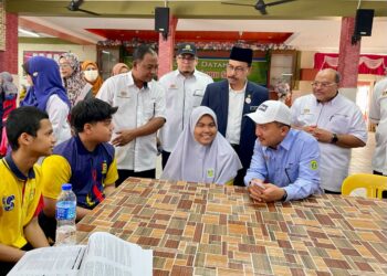 RUJI Ubi (duduk, tengah) bersama calon SPM yang terjejas banjir di asrama penempatan SMK Tunku Abdul Malik di Alor Setar.