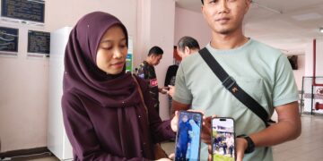 MOHAMAD Norzuhairi Noorisnien (kanan) bersama adiknya, Siti Norizyan Noorisnien menunjukkan gambar kenangan bersama arwah bapa ketika ditemui di Unit Perubatan Forensik Hospital Melaka. 
– UTUSAN/MUHAMMAD SHAHIZAM TAZALI