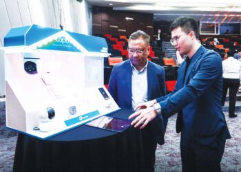 Hugo Cai (kanan) menerangkan perkakasan TP-Link kepada Md. Fauzan pada Majlis Pemeteraian Surat Hasrat (LOI) antara Selangor Industrial Corporation (SIC) dan TP-Link. – UTUSAN/AFIQ RAZALI