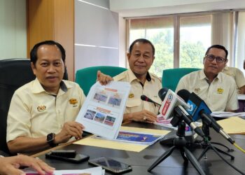 AHMAD Maslan (kiri) menunjukkan laporan jalan-jalan persekutuan dan negeri yang mengalami kerosakan teruk selepas sesi taklimat banjir di Ibu Pejabat JKR Kelantan, Kota Bharu, Kelantan hari ini. - UTUSAN/MUSTAQIM MOHAMED