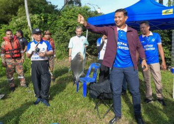 SAARANI Mohamad (kiri) berjaya menaikkan ikan pada Program Memancing Perak Sejahtera 2030 di  Taman Herba Gopeng hari ini. - UTUSAN/ZULFACHRI ZULKIFLI