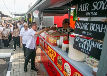 NGA Kor Ming bermesra dengan peniaga ketika melawat gerai jualan MyKiosk Meru Raya pada Program Sentuhan Kejayaan KPKT 2024 di Meru Raya, Ipoh hari ini. - UTUSAN/MUHAMAD NAZREEN SYAH MUSTHAFA