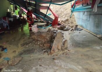 TANAH runtuh menghempap bahagian hadapan sebuah rumah di Kampung Ngangah, Kuala Krai, Kelantan. - IHSAN BOMBA