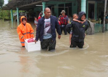 PENDUDUK membawa peralatan peribadi untuk berpindah ke pusat pemindahan sementara (PPS) berhampiran selepas RUMAH mereka di Kampung Baru Tok Kaya Kanan, Kemasik, Kemaman, Terengganu, dinaiki air hari ini. - UTUSAN/PUQTRA HAIRRY