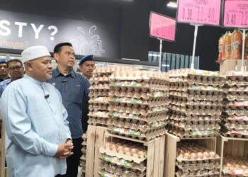 SAHARUDDIN Mohd. Kia (dua dari kiri) memberi penerangan kepada Ariffin Deraman (kiri) mengenai Skim Harga Maksimum Musim Perayaan Krismas 2024 di Kuala Terengganu hari ini. - UTUSAN/KAMALIZA KAMARUDDIN