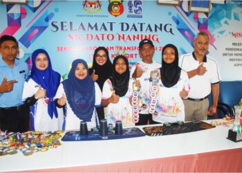 Nur Farizah Md. Zulaili (kiri) dan Nur Farisya Iman (kanan) menunjukkan pingat yang dimenangi di Kejohanan Sukan Stacking Asia ditemani ibu bapa mereka di SK Dato’ Naning, Alor Gajah, Melaka. – UTUSAN/AMRAN MULUP