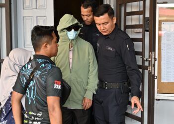 MOHD. Tajudin Mokhtar (tengah) yang dituduh berkomunikasi secara seksual dan amang seksual bukan fizikal terhadap pelajar perempuannya dibawa keluar dari Mahkamah Majistret Marang, Terengganu, semalam. - UTUSAN/PUQTRA HAIRRY ROSLI