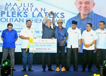 AHMAD Zahid Hamidi (tiga dari kiri) menyampaikan replika cek hasil jualan lateks kepada wakil peserta Agropolitan Chemomoi, di Chemomoi, Bentong, Pahang. - UTUSAN/SHAIKH AHMAD RAZIF