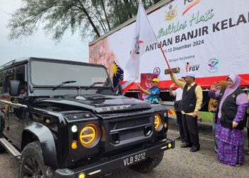 WAN Roslan Wan Hamat (tengah) melepaskan konvoi bantuan banjir FGV pada Majlis Penerimaan dan Penyerahan Bantuan Banjir Daripada FGV Berhad di Dewan Bunga Raya Pantai Sri Tujuh, Tumpat, Kelantan, hari ini. - UTUSAN/MUSTAQIM MOHAMED