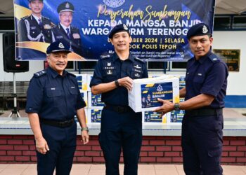 MOHD. Khairi Khairudin (tengah) menyampaikan sumbangan banjir kepada seorang warga polis pada Majlis Penyerahan Sumbangan kepada Mangsa Banjir Warga PDRM Terengganu di Pondok Polis Tepoh, Kuala Nerus, Terengganu, hari ini. - UTUSAN/PUQTRA HAIRRY ROSLI