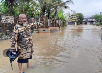 HARUN Samsudin menunjukkan banjir yang melanda Taman Aman di Kota Tinggi, Johor.