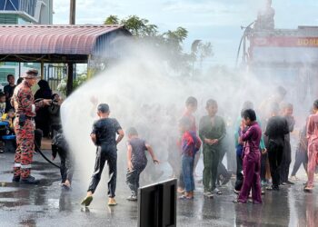 KANAK-kanak terdiri daripada anak yatim asnaf disiram pancutan air daripada bomba sebelum melalui proses bersunat sempena  Program Khatan Perdana di Masjid Al Mustaqim, Seriab, Kangar, Perlis, semalam.-UTUSAN/ASYRAF MUHAMMAD