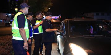 MUHAMMAD Kifli Ma Hassan (kiri) memeriksa kenderaan pada Op bersepadu Khas pada Ambang Tahun Baharu di Kota Bharu, Kelantan, malam tadi. - UTUSAN/KAMARUL BISMI KAMARUZAMAN