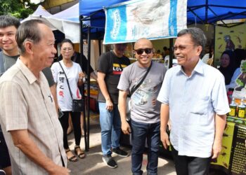 MOHD. Shafie Apdal (kanan) beramah mesra dengan pengunjung di Tamu Jalan Gaya, Kota Kinabalu hari ini.