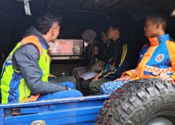 ANGGOTA APM membantu membawa calon SPM ke SMK Kampung Raja ekoran kejadian tanah runtuh di Jalan Besar Kampung Raja, Simpang 3 Blue Valley, Cameron Highlands, Pahang kira-kira pukul 2 pagi tadi.