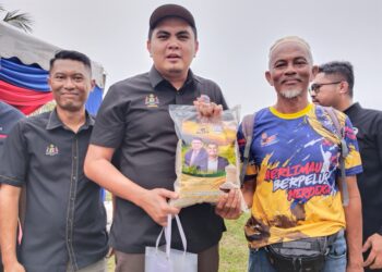 MUHAMAD AKMAL Saleh (dua dari kiri) menunjukkan kampit beras padi MR 297 pada Program Walkabout Projek Benih Padi Negeri Melaka di Merlimau, Melaka.