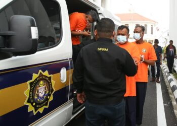 PEGAWAI SPRM Pulau Pinang membawa seorang pegawai rendah polis dan dua lelaki Bangladesh (berbaju jingga) ke kompleks Mahkamah Pulau Pinang bagi mendapatkan perintah reman. UTUSAN/SAFINA RAMLI