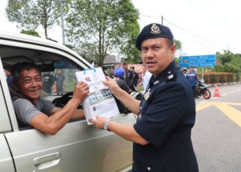 MOHAMMAD Shofee Tayib menyampaikan risalah kepada pemandu pada Program Advokasi Keselamatan Jalan Raya PDRM di hadapan IPD Pontian, di Pontian, petang ini.