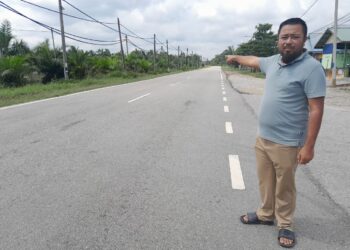 MUHAMMAD Iffat Asmadi menunjukkan jalan utama di Kampung Gembut yang dinaiki air setiap kali banjir.