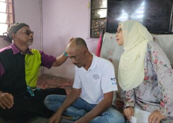 PENAUNG CSM, Datuk Mohd. Asri Redha (kiri) bersama Pengerusinya, Zuraini Kamal melihat kesan ketumbuhan di kepala Mohamad Nazir Saad ketika berkunjung di Kampung Permatang Kaka, Kodiang di Kubang Pasu.