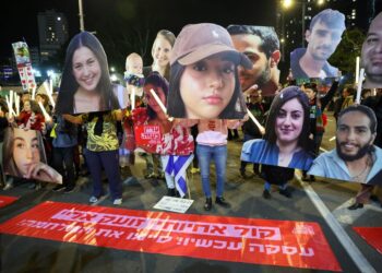 PENUNJUK perasaan memegang potret tebusan yang ditawan di Gaza ketika demonstrasi menggesa pembebasan mereka di luar ibu pejabat Kementerian Pertahanan di Tel Aviv.-AFP