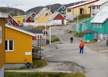 PENDUDUK berjalan di kawasan penempatan terpencil di Kangaamiut di pantai barat Greenland.-AFP