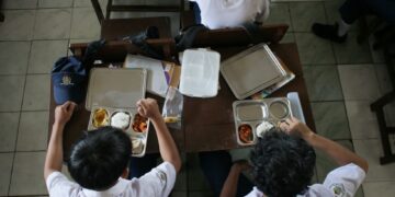 PELAJAR Sekolah Menengah Rendah PGRI 6 Bogor, Jawa Barat menikmati hidangan pada hari pertama program makanan percuma, semalam.- AFP