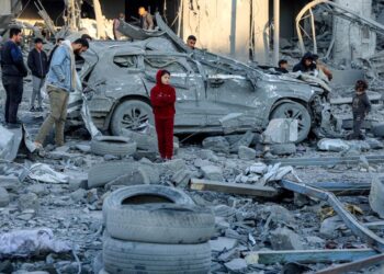 PENDUDUK Palestin melihat runtuhan bangunan dan kereta yang musnah dibedil Israel di blok kediaman di Jalan Jalaa di Gaza City.-AFP