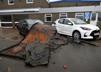 DUA buah kereta rosak akibat terkena serpihan bumbung yang runtuh di luar kawasan kedai di Helensburgh, Scotland.-AFP