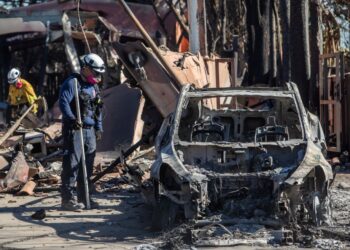 ANGGOTA bomba meninjau sebuah kereta dan rumah yang musnah dalam kebakaran Palisades di kejiranan Pacific Palisades, di Los Angeles, California pada Rabu lalu.- AFP