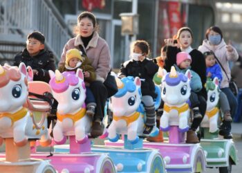 BEBERAPA wanita membawa anak-anak beriadah di taman permainan di Fuyang, wilayah Anhui di timur China.-AFP