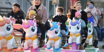 BEBERAPA wanita membawa anak-anak beriadah di taman permainan di Fuyang, wilayah Anhui di timur China.-AFP