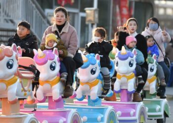 BEBERAPA wanita membawa anak-anak beriadah di taman permainan di Fuyang, wilayah Anhui di timur China.-AFP