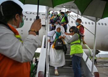 ANGGOTA sukarelawan membantu jemaah haji warga emas yang tiba di Lapangan Terbang Antarabangsa Sultan Iskandar Muda di Blang Bintang, wilayah Aceh pada 10 Julai 2024.-AFP