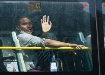 BANDUAN yang dibebaskan melambai dari bas selepas dibawa keluar dari Penjara Insein di bawah pengampunan sempena Hari Kemerdekaan Myanmar di Yangon, pada 4 Januari 2024.- AFP