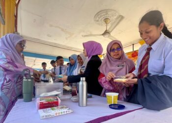 PENGETUA SMK Dato’ Sheikh Ahmad, Adilah Muhammad Nor (dua dari kanan) membantu menyiapkan roti bakar buat calon yang menduduki peperiksaan bertulis SPM 2024, hari ini. -UTUSAN/ASYRAF MUHAMMAD