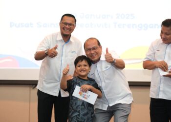 MUHTAR Suhaili (kiri) bersama salah seorang daripada 100 murid kurang berkemampuan yang menerima sumbangan CSR Epic Bhd. Kembali Ke Sekolah 2025 di Kuala Terengganu, hari ini. - UTUSAN/KAMALIZA KAMARUDDIN