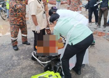 PEGAWAI perubatan memberi bantuan rawatan kepada lelaki warga Bangladesh yang terjatuh dari kerangka besi di tapak pembinaan di Bandar Meru Raya di Ipoh hari ini. - UTUSAN/IHSAN JBPM PERAK