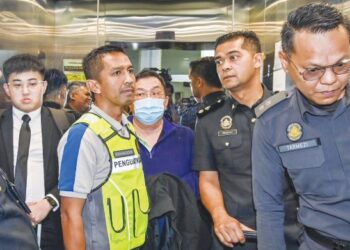 EWE Sarn Yeun (pakai pelitup muka) yang didakwa atas penemuan produk yang diragui status halal tiba di Mahkamah Sesyen Petaling Jaya, semalam. – UTUSAN/SYAKIR RADIN