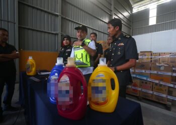 MUHAMMAD Nizam Jamaludin (tengah) menunjukkan cecair pencuci pakaian tiruan yang dirampas pada sidang akhbar di stor KPDN Kedah di Tunjang, Kubang Pasu hari ini.