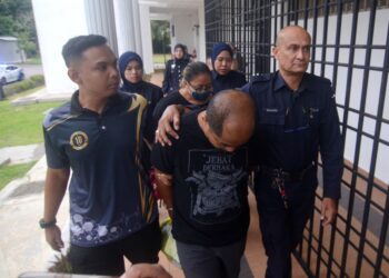 MOHD, Nasir Othman (depan, tengah) ketika dibawa ke Mahkamah Majistret Balik Pulau, Pulau Pinang hari ini.-UTUSAN/IQBAL HAMDAN