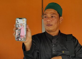 ABU Mansur Ahmad Musa menunjukkan gambar arwah isterinya, Siti Fatimah (kiri) ketika dia ditemui pemberita di Unit Forensik Hospital Kota Tinggi, Johor hari ini. UTUSAN/MASTURAH SURADI