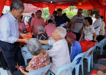 MOHAMAD Hasan menyampaikan sumbangan Tahun Baru Cina kepada warga emas di Rumah Nam Tai, Taman Marida, Senawang, Seremban hari ini.-UTUSAN/MOHD. SHAHJEHAN MAAMIN