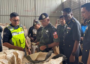 SHAHRUM Hashim (dua dari kiri) dan Jegan (dua dari kanan) meneliti bungkusan baja tanpa lesen di sebuah premis di Permatang Saga, Pinang Tunggal, Pulau Pinang hari ini.-UTUSAN/SITI NUR MAS ERAH AMRAN