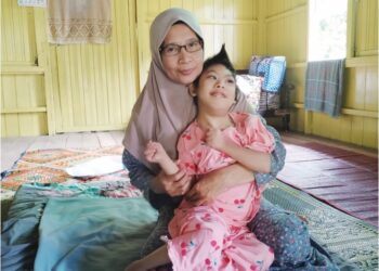 BIBI Naziraini Mat Ghani memangku Siti Nurul Batrisya Mat Imi di rumah mereka  di Kampung La, Hulu Besut, Besut, Terengganu. –UTUSAN/WAN ZURATIKAH IFFAH