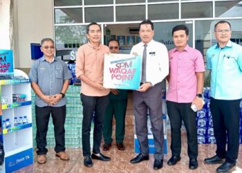 ARMI Irzan Mohd. (dua, kiri) menyerahkan sumbangan air minuman kepada Khairi Mohd. Nor sempena Program SPM Waqaf Point  di Kuala Terengganu, hari ini.