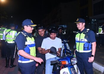 SYED AHMAD KHIRULANWAR ALYAHYA Syed Abdul Rahman (kiri) memeriksa lesen memandu seorang penunggang motosikal dalam Ops Khas Motosikal 2024 di bandar Kuantan di Kuantan, Pahang. - FOTO/SHAIKH AHMAD RAZIF