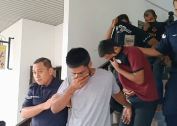 KESEMUA tertuduh diiringi anggota polis ketika dihadapkan ke Mahkamah Majistret, Ayer Keroh, Melaka. - UTUSAN/MUHAMMAD SHAHIZAM TAZALI