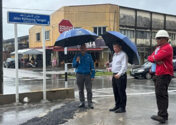 SIM Chon Siang (tengah) meninjau keadaan jalan yang ditutup bagi memberi lakuan kepada kerja pembinaan loji rawatan kumbahan di Kampung Tengah di Kuantan, Pahang.