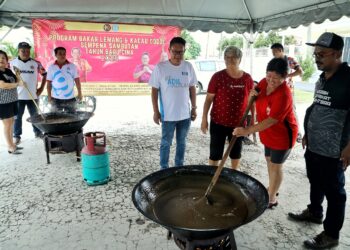 PENDUDUK dalam kalangan masyarakat Cina Kampung Seri Sikamat, Seremban tidak ketinggalan mengacau dodol pada program membakar lemang dan mengacau dodol anjuran Kelab Waris Anak Melayu Negeri Sembilan 05, semalam.-UTUSAN/MOHD. SHAHJEHAN MAAMIN.